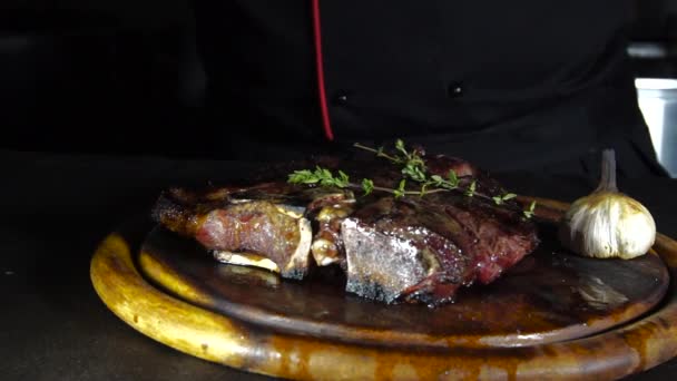 Smažený steak na grilu leží na dřevěném prkénku s zeleninou — Stock video