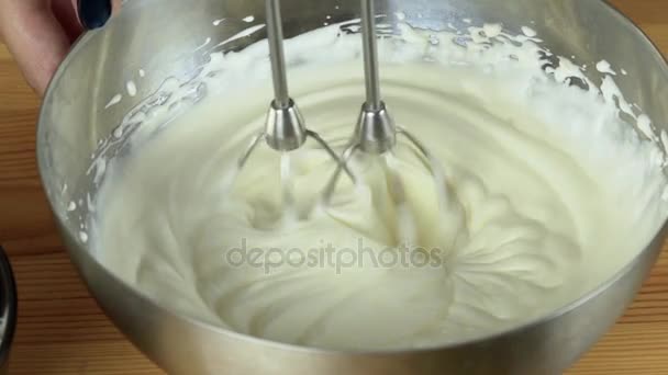 Close up: Whisks whipped egg whites and sugar in the bowl of glass. Whisk in glass bowl of raw egg in slow motion. Whisk for whipping. Whip the egg white: cook at home, make a cake, desserts, meringue — Stock Video