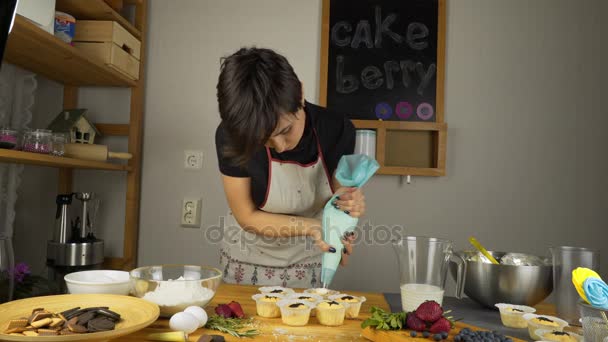 Cooking cupcakes. Apply cream. — Stock Video