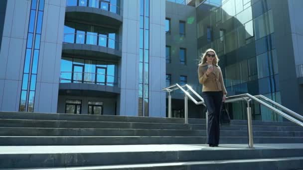 Hermosa, elegante, mujer de negocios hablando por teléfono al aire libre cerca del edificio de oficinas. Ella es una muy feliz, alegre y sonriente muy linda — Vídeos de Stock