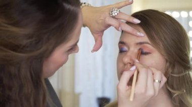Bir makyaj master modeli görüntü güzellik salonu'için hazırlar. Makyaj sanatçısı, profesyonel bir makyaj yapar.