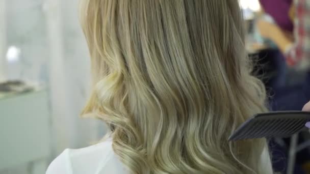 Жінка з довгим волоссям в салоні краси отримує повітродувку — стокове відео