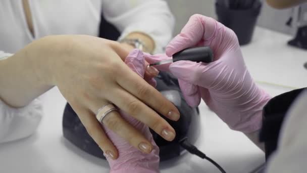 Chica en el salón de belleza hace una manicura — Vídeo de stock