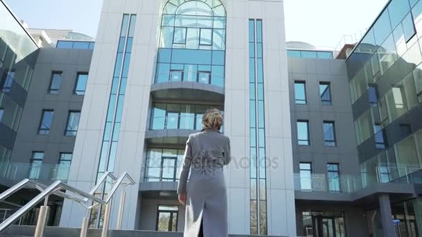 Hermosa, elegante, mujer de negocios hablando por teléfono al aire libre cerca del edificio de oficinas. Ella es una muy feliz, alegre y sonriente muy linda — Vídeos de Stock