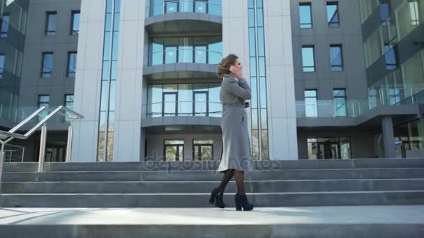 Mooie, stijlvolle, zakenvrouw, praten over de telefoon buiten in de buurt van kantoorgebouw. Ze is een heel gelukkig, vrolijk en glimlachend heel schattig — Stockvideo