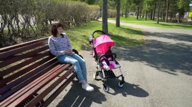 Bir bebek arabası ve telefon elinde kadın ile