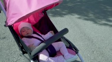 Bebek arabasında uyuyan tatlı küçük oğlan.