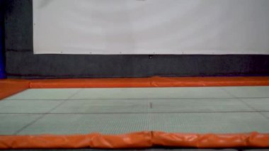Genç erkekler, trambolin içinde kapalı Bahçesi atlama. Aktif insanlar erkek spor Merkezi'nde eğleniyor. Ağır çekim