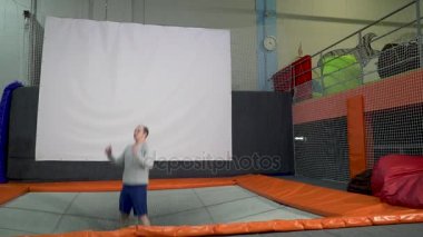 Genç erkekler, trambolin içinde kapalı Bahçesi atlama. Aktif insanlar erkek spor Merkezi'nde eğleniyor. Ağır çekim