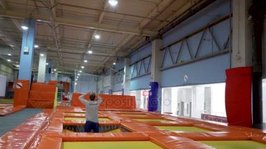 Genç erkekler, trambolin içinde kapalı Bahçesi atlama. Aktif insanlar erkek spor Merkezi'nde eğleniyor. Ağır çekim
