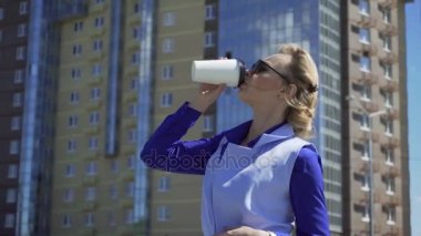 içme kahve dışında kentsel arka plan üzerinde neşeli şık iş kadını