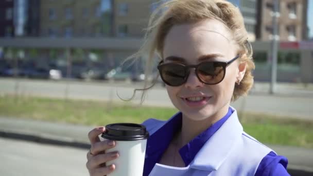 都市の背景に外でコーヒーを飲む陽気なスタイリッシュな女性実業家 — ストック動画