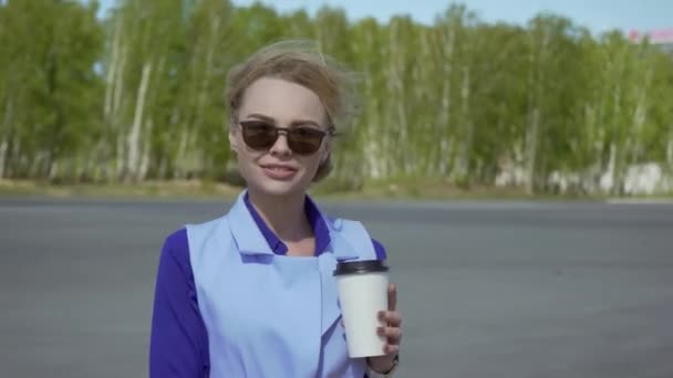 都市の背景に外でコーヒーを飲む陽気なスタイリッシュな女性実業家 — ストック動画