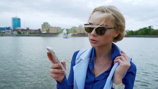 Feche a foto de uma empresária sorridente usando um telefone celular na cidade ao lado do rio . — Vídeo de Stock