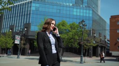 Telefonda konuşurken bir iş kadını. Arka planda bir iş merkezidir.