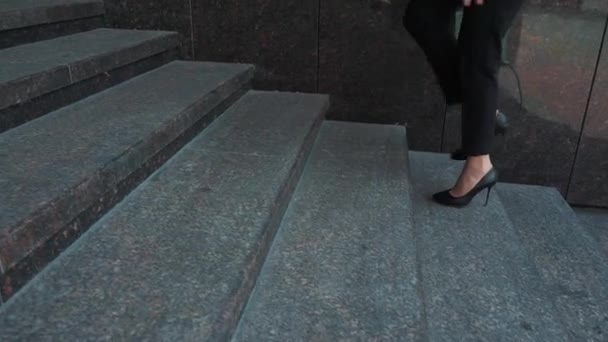 Unterteil einer Geschäftsfrau im formellen Anzug, die die Außentreppe hinaufgeht. — Stockvideo