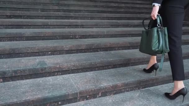 屋外階段を登ってフォーマルなスーツでビジネス女性の下の部分. — ストック動画