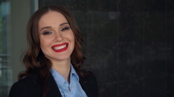 Sexy mujer seductora con lápiz labial rojo y de pie en las escaleras en el pasillo del edificio de oficinas y mirando a la cámara — Vídeos de Stock