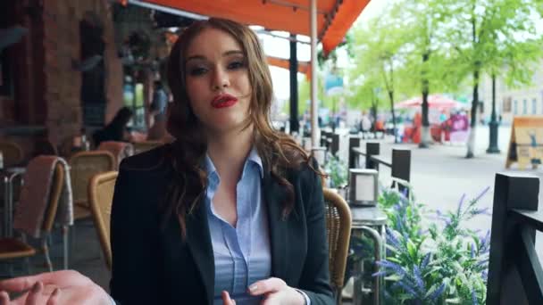 Una ragazza e 'seduta in un caffe', con un completo da lavoro. La ragazza è molto sexy e bella. Racconta una storia . — Video Stock