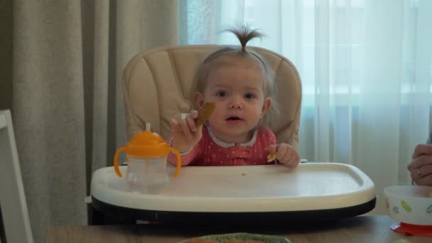 A mãe alimenta a filha. Menina comer biscoitos — Vídeo de Stock