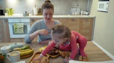 Aile, yemek, çocuk, beslenme ve babalık - mutlu genç anne ile evde masaya oturmuş, peynir yeme bebek kahvaltı anlayışı