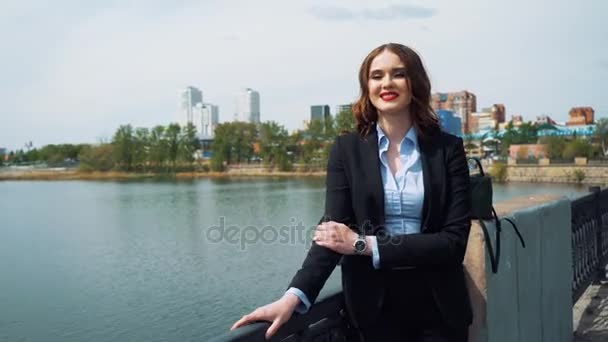 Mädchen im Businessanzug mit Tasche am Wasser. — Stockvideo