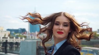 Kentsel şehir arka plan karşı katlanmış el ile ayakta bir mutlu genç iş kadını portresi