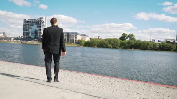 Empresario con valiente regocijo y afortunado y afortunado de ganar. Se ve próspero en traje y corbata al aire libre. Fondo de edificio moderno . — Vídeos de Stock