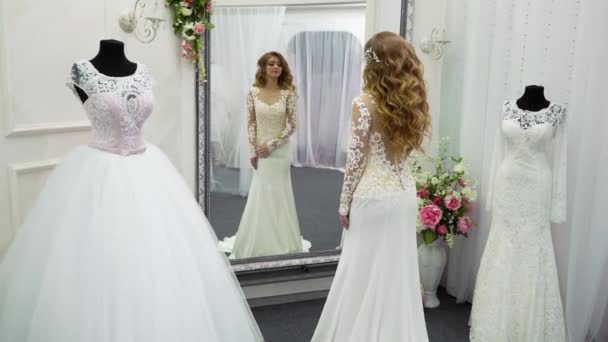Γυναίκα επιλέγοντας γαμήλια φόρεμα στο κατάστημα — Αρχείο Βίντεο
