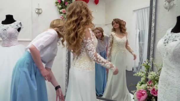 Подружки вибирають весільну сукню в бутіку — стокове відео
