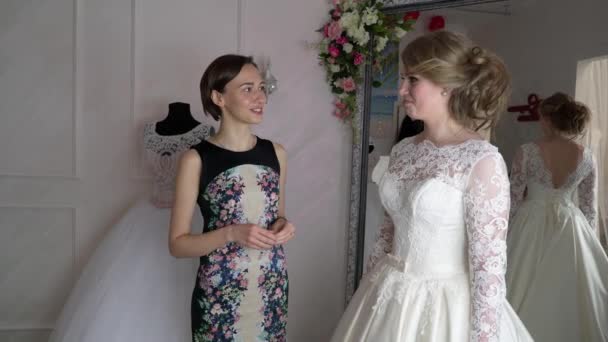Nevěsta v obchodě oblečení pro svatební šaty jí je volba šaty a návrháři jí pomáhá — Stock video