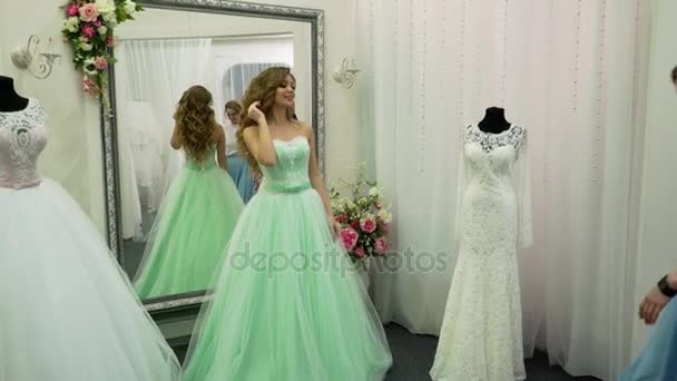Junge Frau wählt Hochzeitskleid im Brautladen — Stockvideo