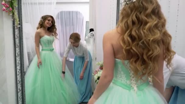 Ung kvinna väljer en brudklänning i bridal shop — Stockvideo