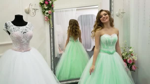 Молодая женщина выбирает свадебное платье в свадебном магазине — стоковое видео