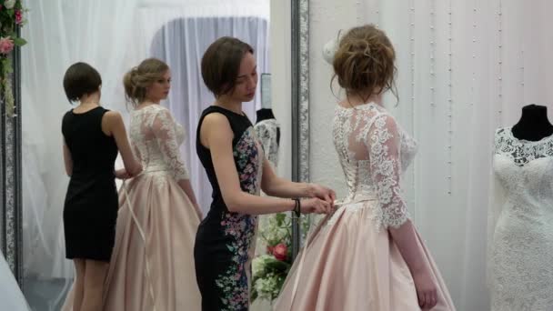 Namoradas escolhe vestido de casamento na boutique — Vídeo de Stock