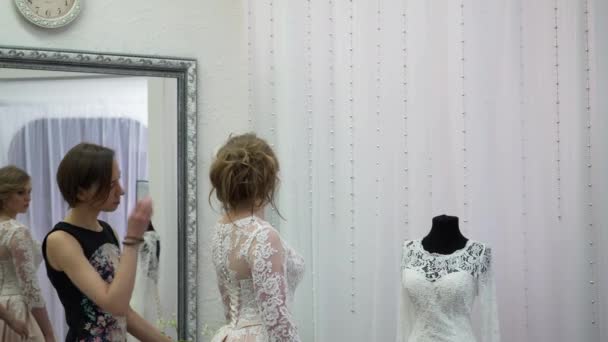 Freundinnen wählen Hochzeitskleid in Boutique — Stockvideo