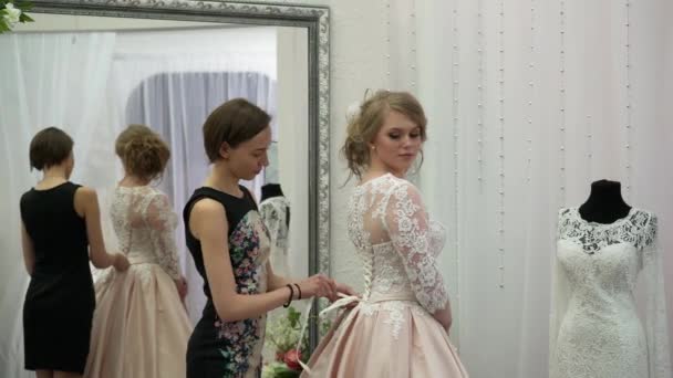Консультант помог будущей невесте выбрать свадебное платье — стоковое видео