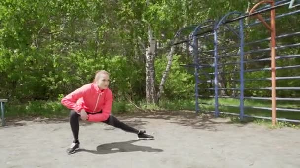 Jeune femme fitness coureur étirant les jambes avant de courir — Video