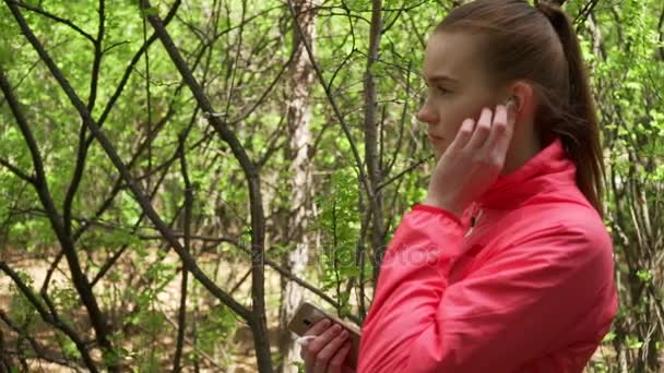 年轻漂亮的女人在秋天公园跑步和听音乐的耳机. — 图库视频影像