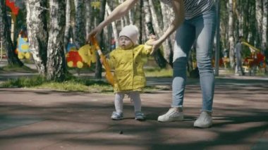 Küçük bebek ile anne parkta yürüyüş zevk: onlar el ele tutuşarak