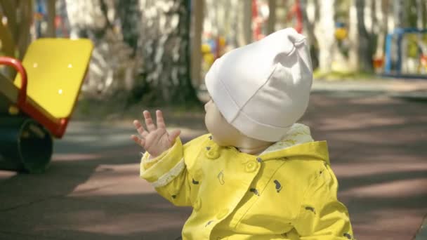 Веселый забавный ребенок играет на детской площадке осенью . — стоковое видео