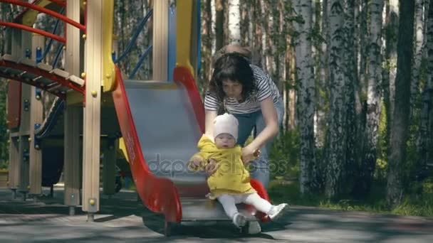 Мама и ребенок играют на детской площадке — стоковое видео