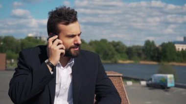 İşadamı telefonda konuşan ve çok kızgın. O bağırıyor ve yemin ediyor. Ağır çekimde