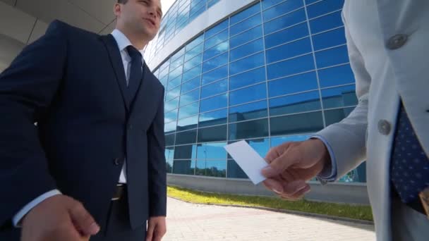 Dos hombres de negocios intercambiando tarjetas de visita y hablando — Vídeos de Stock