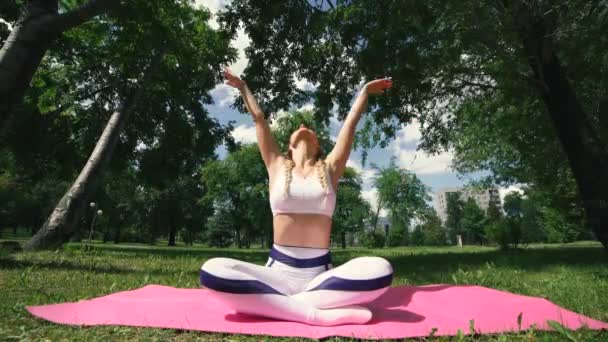 Fitness femme posée sur tapis de yoga dans le parc d'été. Femme de remise en forme se préparant pour fitness .