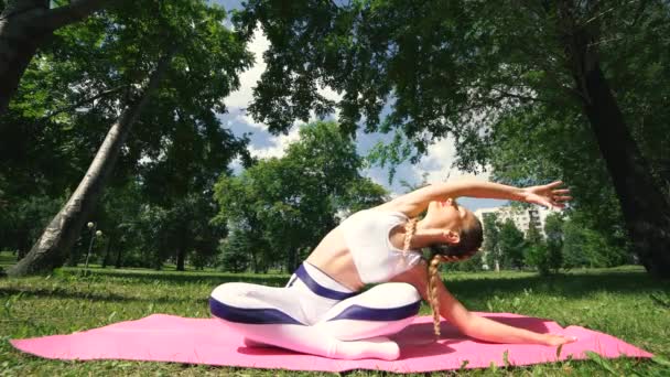 Fitness-Frau liegt auf Yogamatte im Sommerpark. Fitness-Frau bereitet sich auf Fitness vor. — Stockvideo