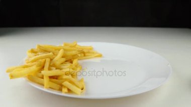 Kızarmış patates cipsi düşüyor, ağır çekim, lokanta, abur cubur kavramı üzerinde aşağı hamburger.