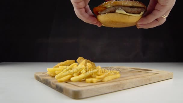 Maschio mette giù un hamburger poco appetitoso ad alto contenuto di colesterolo e grassi saturi — Video Stock