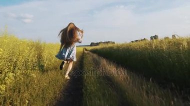 Yolun aşağısında bir güneşli yaz gününde tatil çalışan uzun saçlı bir kız.