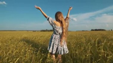 Güzellik kız açık havada zevk doğa. Bahar sahada çalışan, güneş ışığı elinde Raising elbiseli güzel genç Model kız.